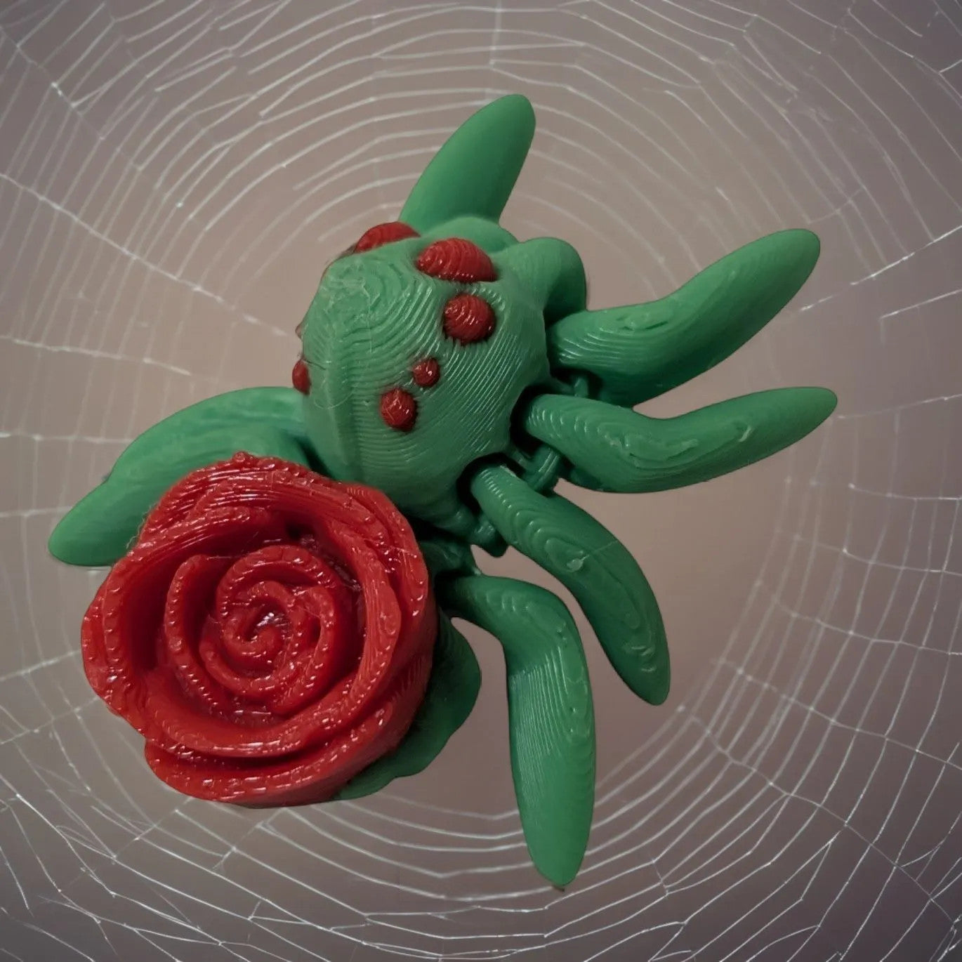 Mehrfarbige, flexible 3D-gedruckte Rosenspinne mit Rose auf dem Rücken